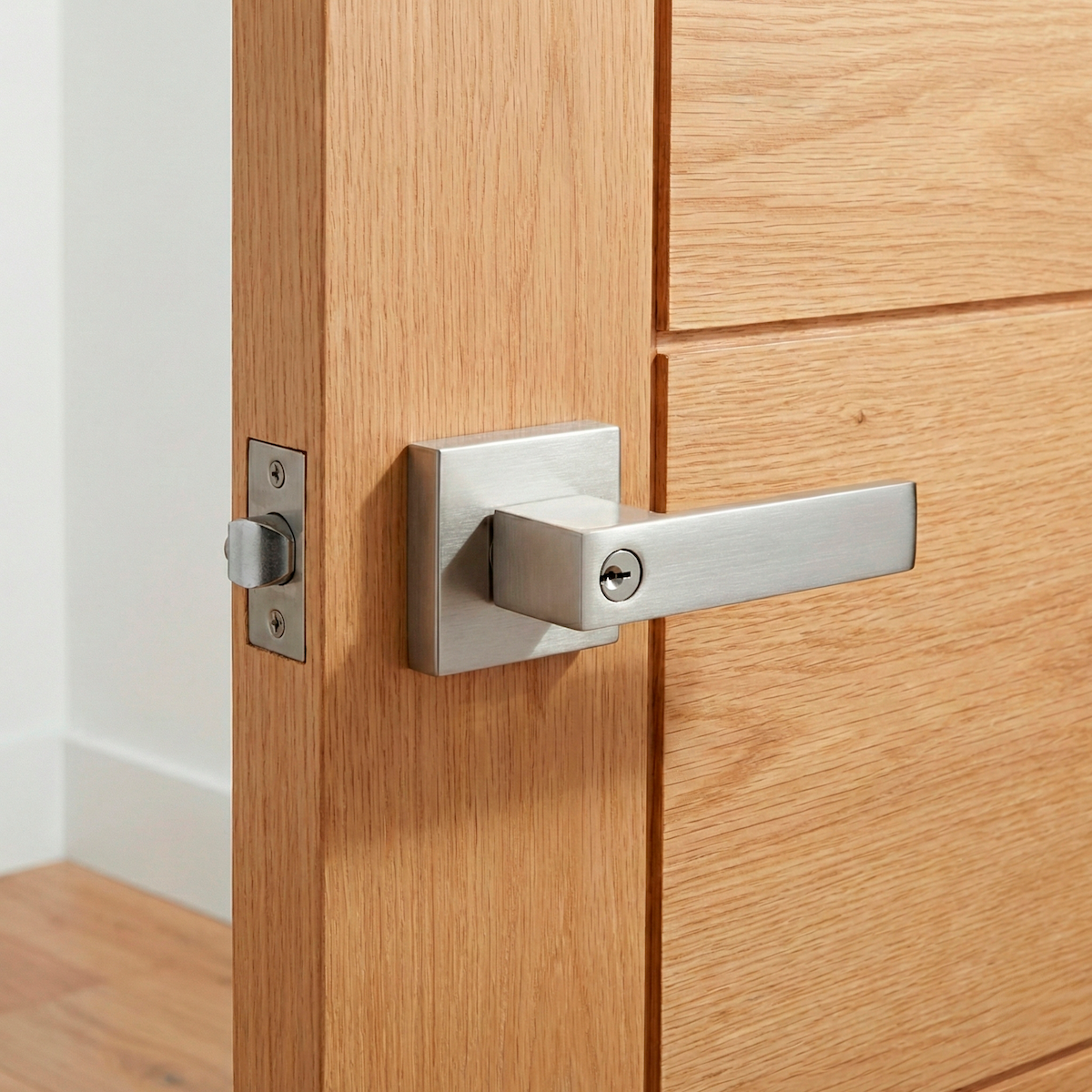 Poignée modèle Luke en finition nickel satiné avec serrure intégrée et rosace carrée pour portes d'entrée